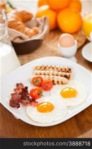 Photo of breakfast table with a plate of delicious english breakfast
