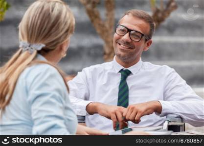 Photo of businessman on wheelchair talks to his colleague