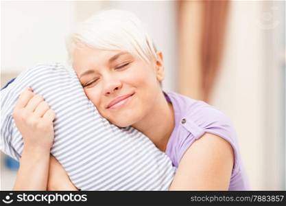 photo of caucasian blonde woman hugging a pillow