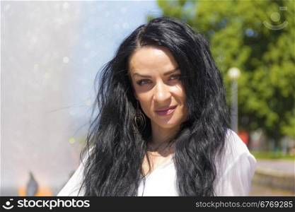 Photo of Caucasian brunette woman on fountain background