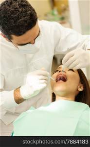 photo of caucasian male dentist visiting his young asian female patient in a dentist office