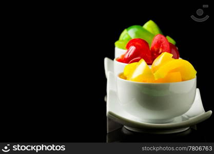 photo of colorful pepper inside three small bowls on black isolated background