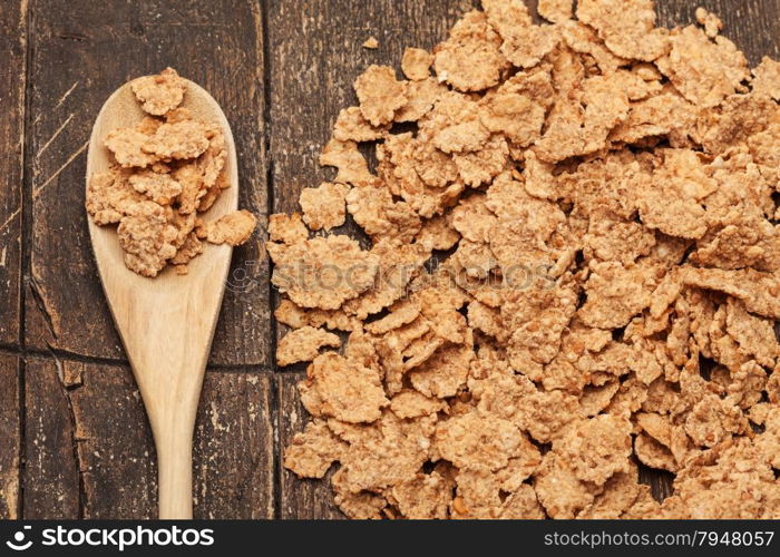 Photo of corn flakes over old wooden table