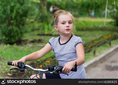 Photo of cute girl driving bicycle in summer