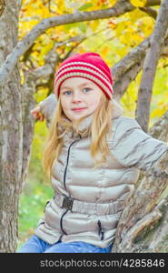 Photo of cute girl in autumn sit on tree