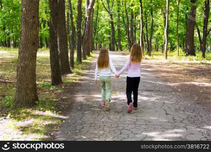 Photo of cute two girls walking in park