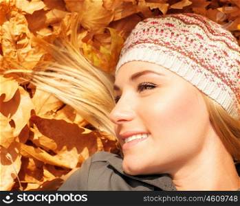 Photo of cute young lady laying down on the ground in autumn park, cute blond teenager having fun outdoors, having fun, rest outdoor, pleasure expression, fall season, freedom and carefree concept&#xA;