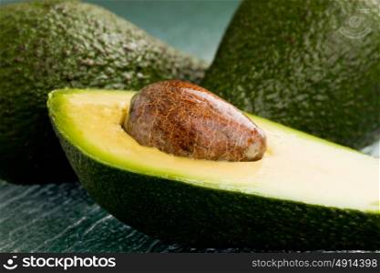 photo of cutted avocado fruit on green glass table