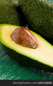 photo of cutted avocado fruit on green glass table