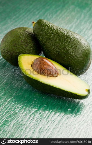 photo of cutted avocado fruit on green glass table