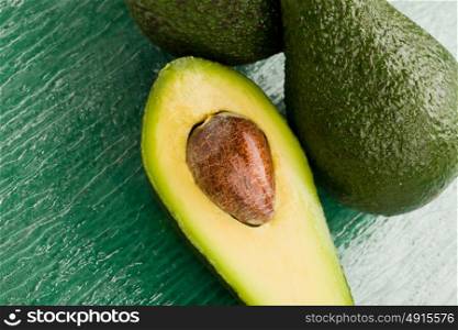 photo of cutted avocado fruit on green glass table