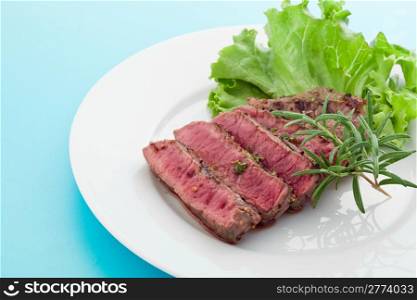 photo of delicious and pefect cooked beaf steak with rosemary and lettuce