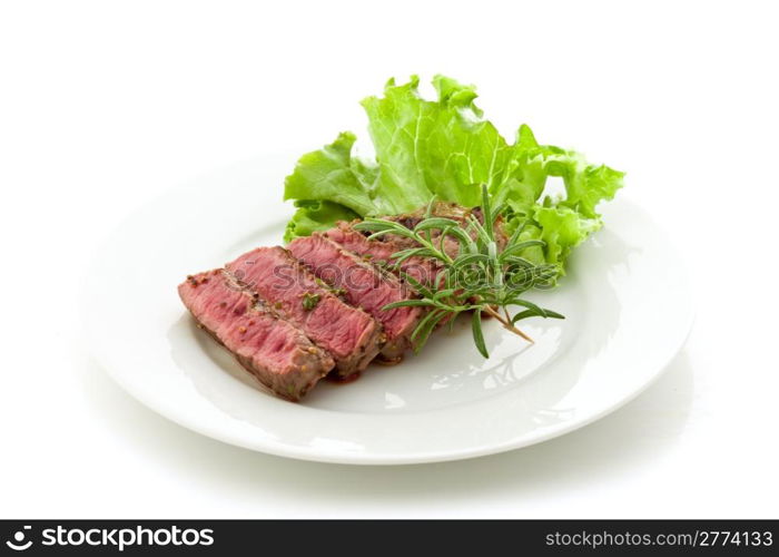 photo of delicious and pefect cooked beaf steak with rosemary and lettuce