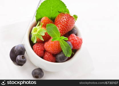 photo of delicious berries with mint on white isolated background