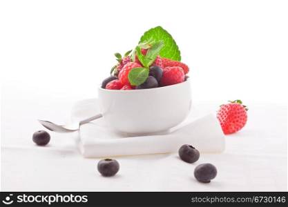 photo of delicious berries with mint on white isolated background