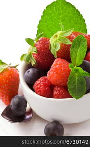 photo of delicious berries with mint on white isolated background