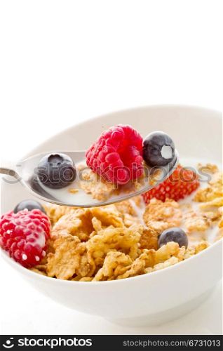 photo of delicious breafast isolated on white made of corn flakes with berries and fresh milk