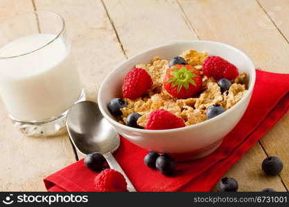 photo of delicious breafast made of corn flakes with berries and fresh milk