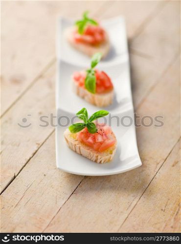 photo of delicious bruschetta with tomatoes on wooden table