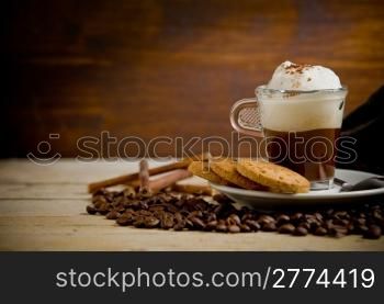 photo of delicious cappuccino on coffee beans with biscuits