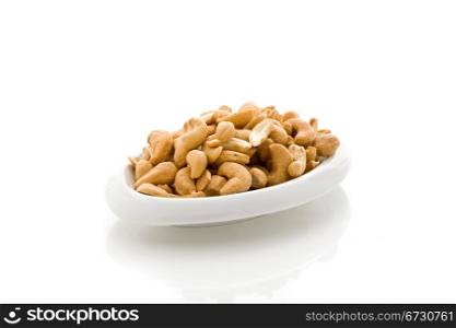 photo of delicious cashews inside a plate on white isoalted background