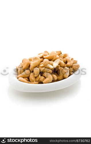 photo of delicious cashews inside a plate on white isoalted background