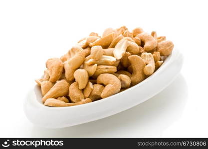 photo of delicious cashews inside a plate on white isoalted background