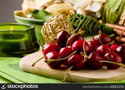 photo of delicious cherries on cutting board with decoration arround