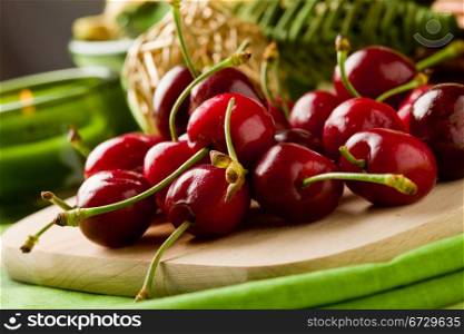 photo of delicious cherries on cutting board with decoration arround