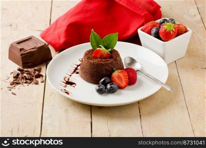 photo of delicious chocolate dessert with berries on wooden table