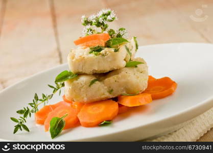 photo of delicious cod over carrots with fresh oregano and basil