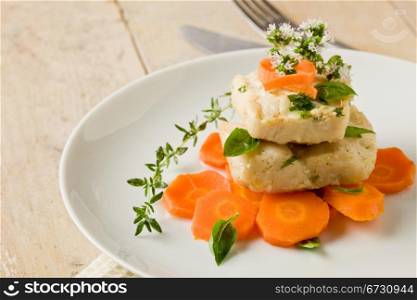 photo of delicious cod over carrots with fresh oregano and basil