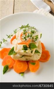 photo of delicious cod over carrots with fresh oregano and basil