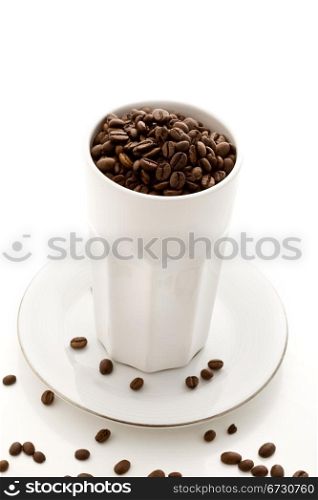 photo of delicious coffee beans inside a glass on white isolated background