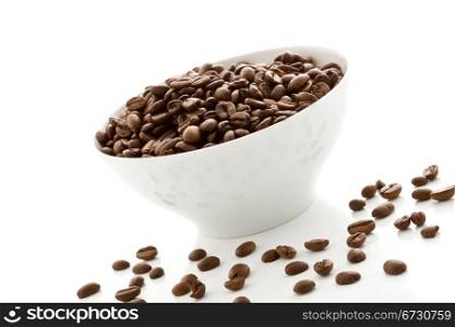 photo of delicious coffee beans inside a white bowl on white isolated background