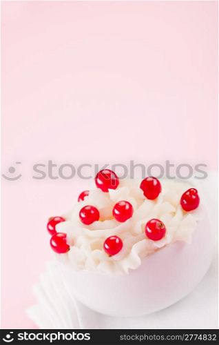 photo of delicious cream dessert with currants on rose background