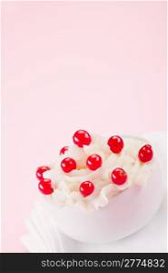 photo of delicious cream dessert with currants on rose background