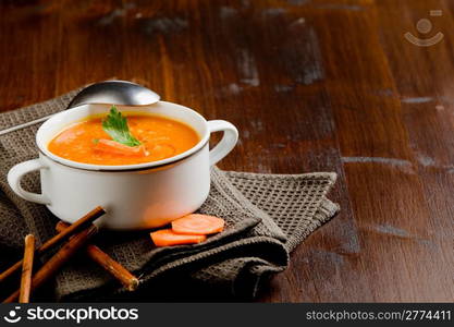 photo of delicious creamy smooth carrot soup on wooden table