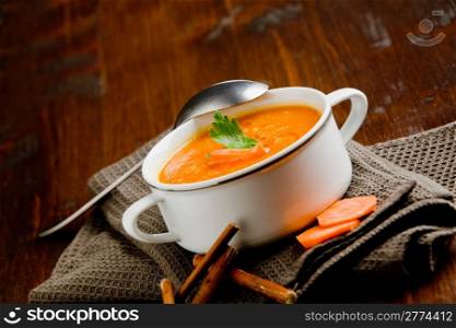 photo of delicious creamy smooth carrot soup on wooden table