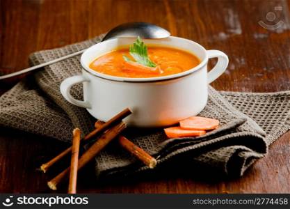 photo of delicious creamy smooth carrot soup on wooden table