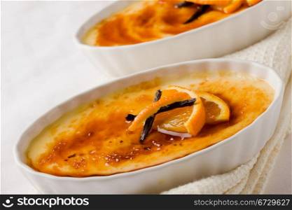 photo of delicious creme brule dessert on white towel with blue background