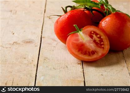 photo of delicious fresh tomatoes with basil leaves on wooden table