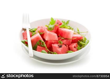 photo of delicious fresh watermelon and arugula salad on isolated background