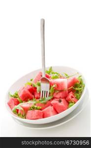 photo of delicious fresh watermelon and arugula salad on isolated background