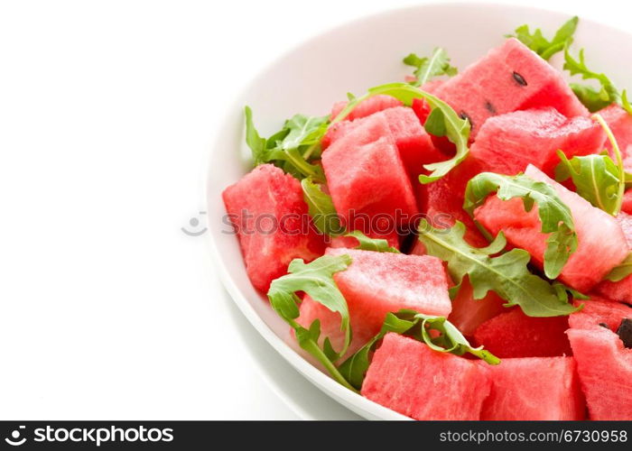 photo of delicious fresh watermelon and arugula salad on isolated background