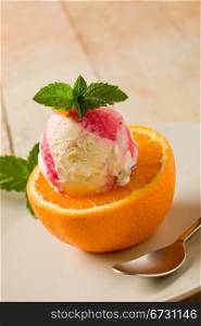photo of delicious fruity ice cream on cutted orang with fresh mint leaves