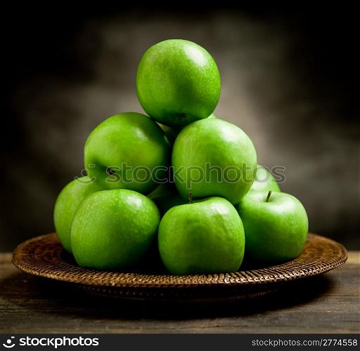 photo of delicious green apple inside a basket on wooden table