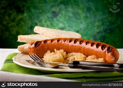 photo of delicious grilled hot dog with sauerkraut and bread,