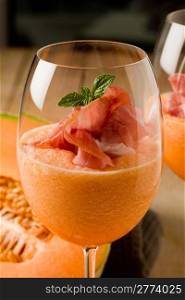 photo of delicious ham and melon cocktail appetizer on wooden table