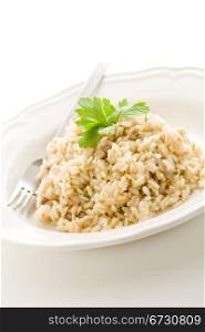 photo of delicious italian risotto dish with meat and parsley on white isolated background